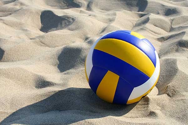 A beach volleyball resting on the sand