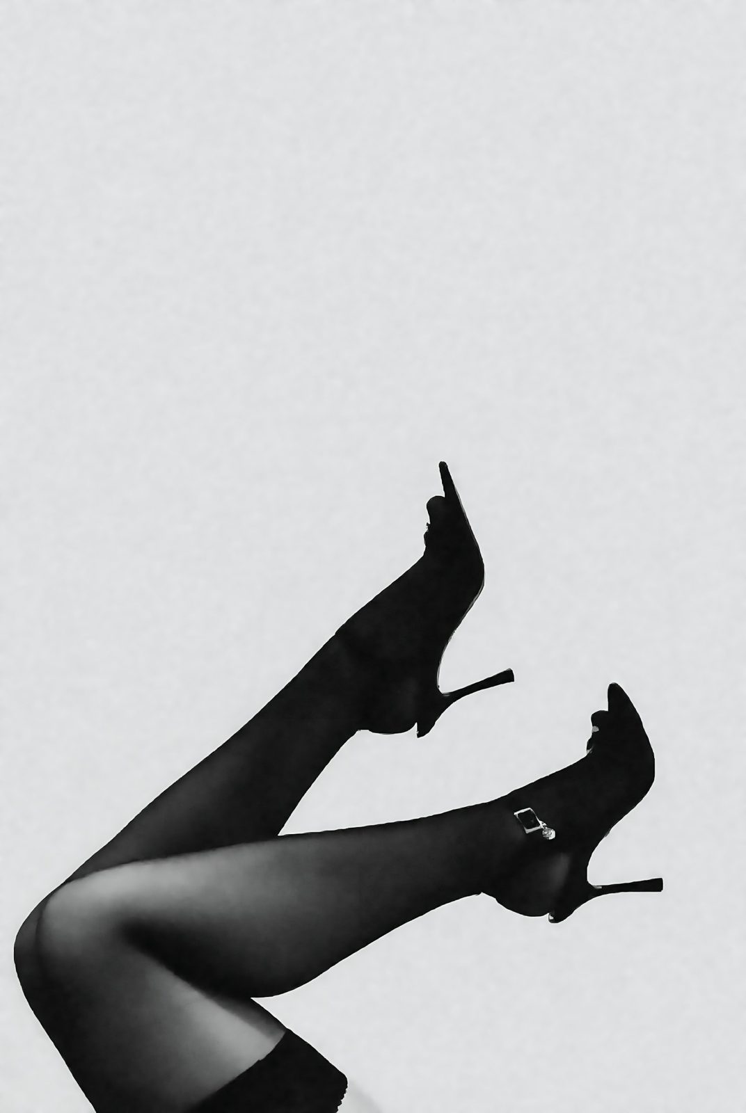 Legs in black tights and heels raised in the air